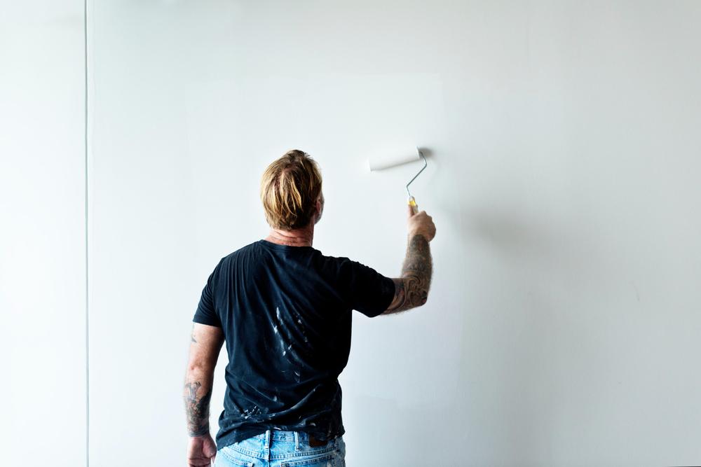 homme qui peint un mur en blanc