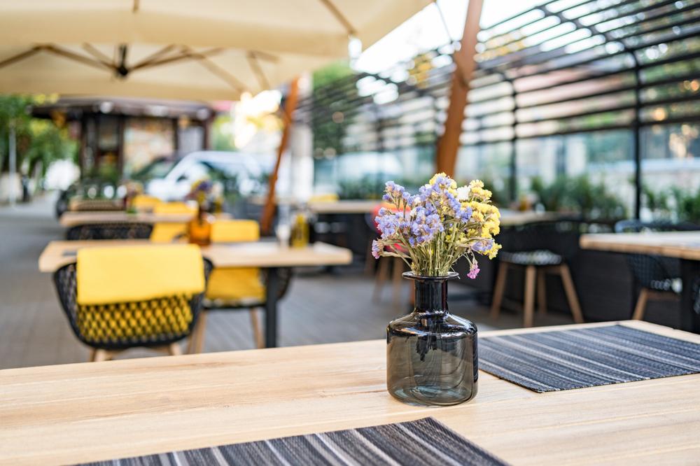 une terrasse de restaurant avec un bouquet de fleurs sur la table