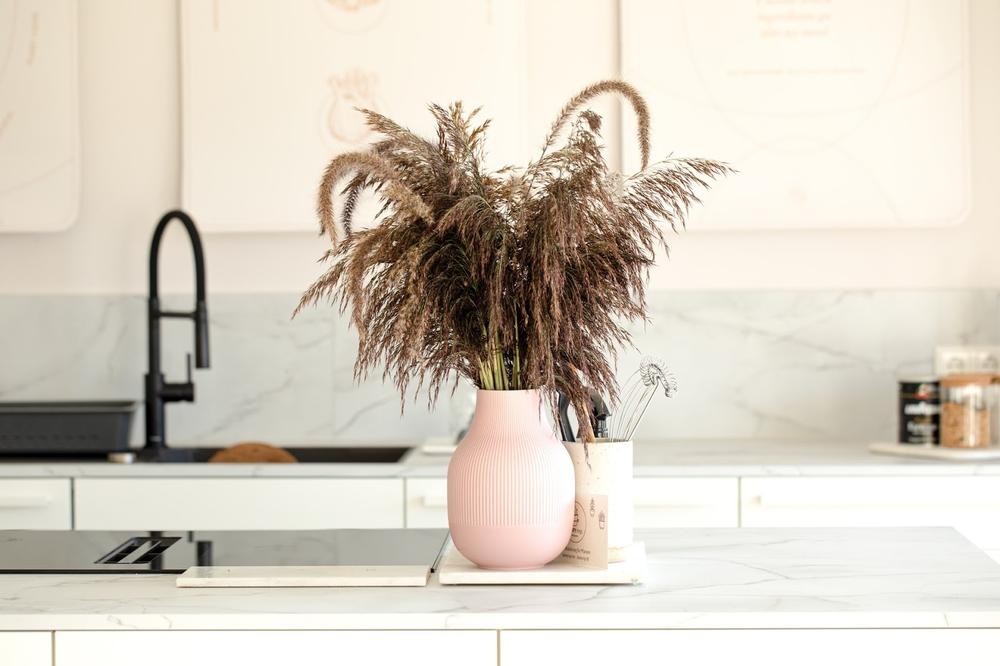 un vase rose sur un ilot central dans cuisine
